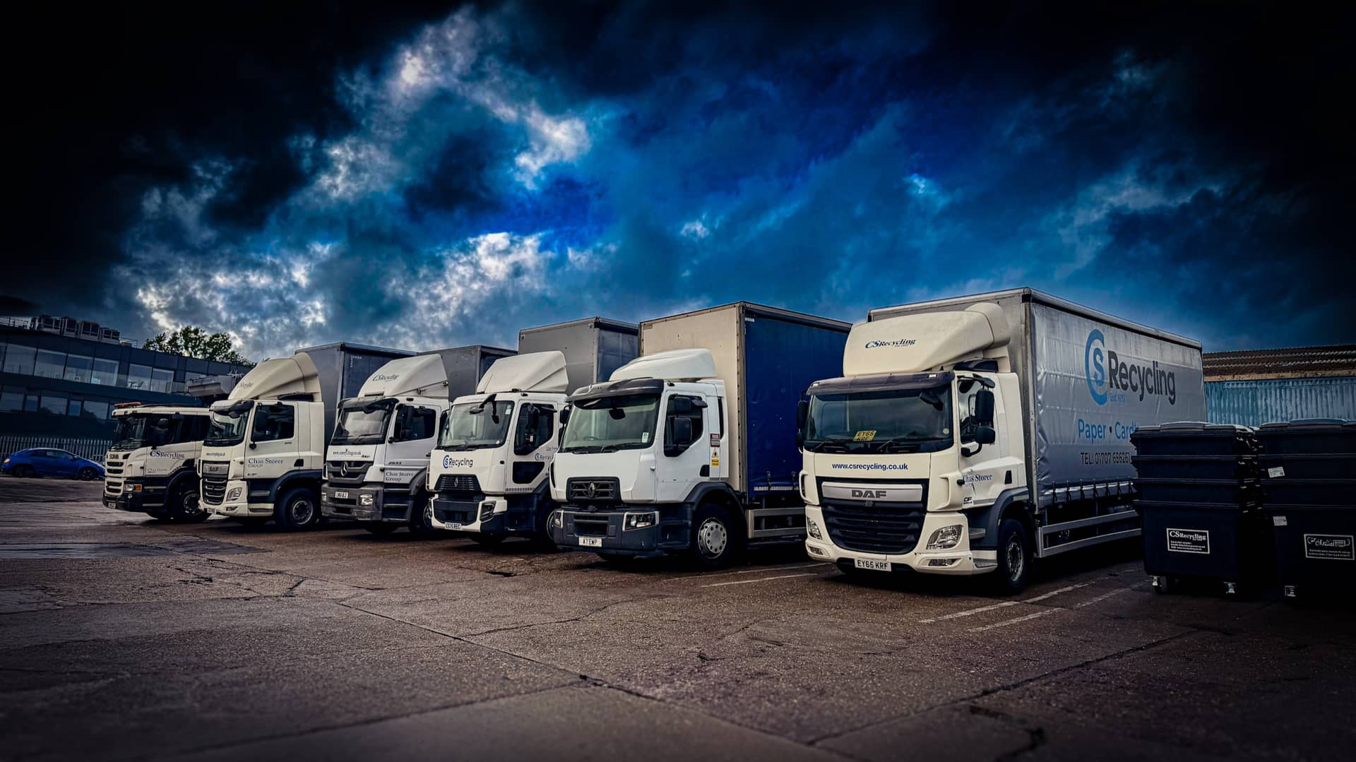 A line of commercial fleet vehicles parked at a customer depot