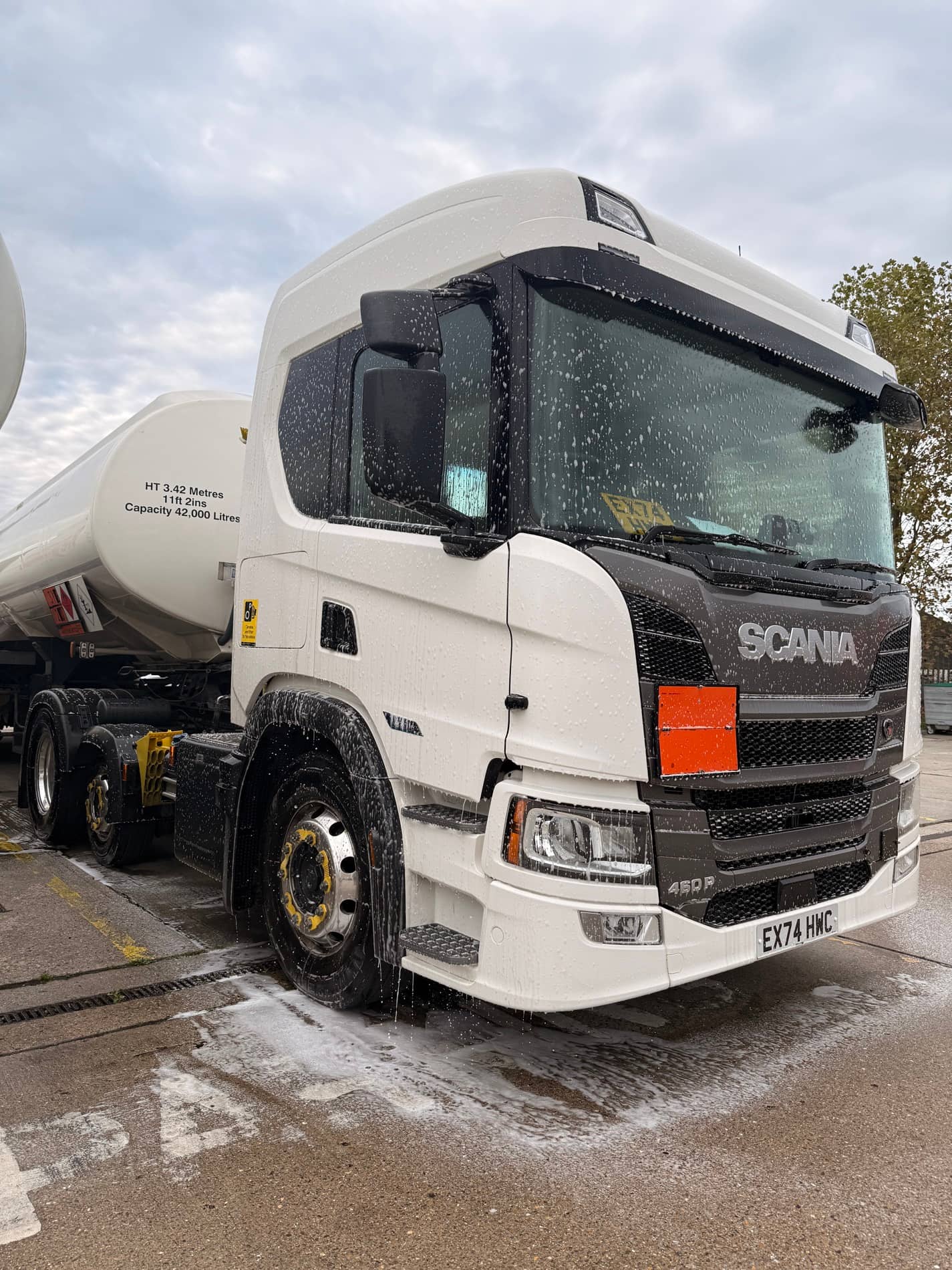 Commercial tractor unit covered with cleaning foam during preparation work